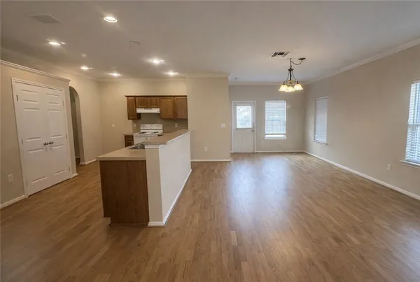 a view of a kitchen with cabinets and wooden floor