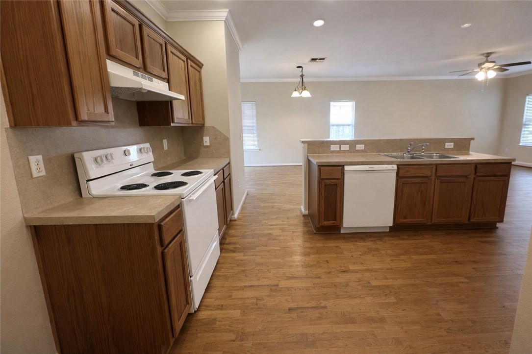 1022 Livermore Street Portland, TX 78374 - Photo 5 of 14 a kitchen with kitchen island a sink appliances and cabinets