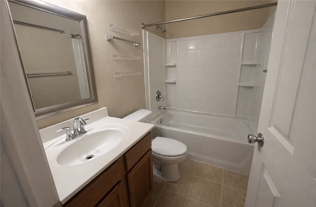 1022 Livermore Street Portland, TX 78374 - Photo 9 of 14 a bathroom with a sink a toilet and shower a mirror