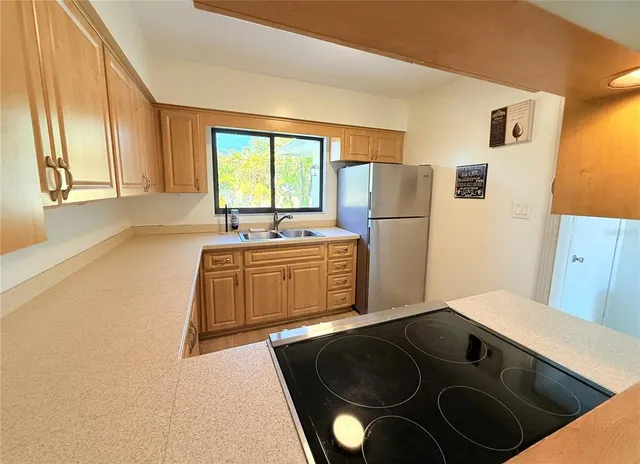 a kitchen with a stove a refrigerator and a sink