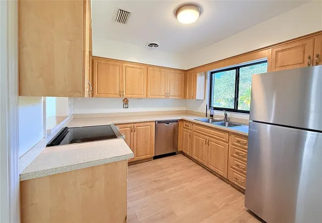 a kitchen with a refrigerator a sink and a stove top oven