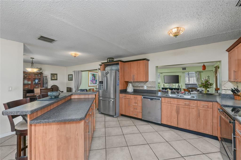 1432 Windmill Pointe Road Palm Harbor, FL 34685 - Photo 19 of 44 a kitchen with stainless steel appliances granite countertop lots of counter top space and wooden floor