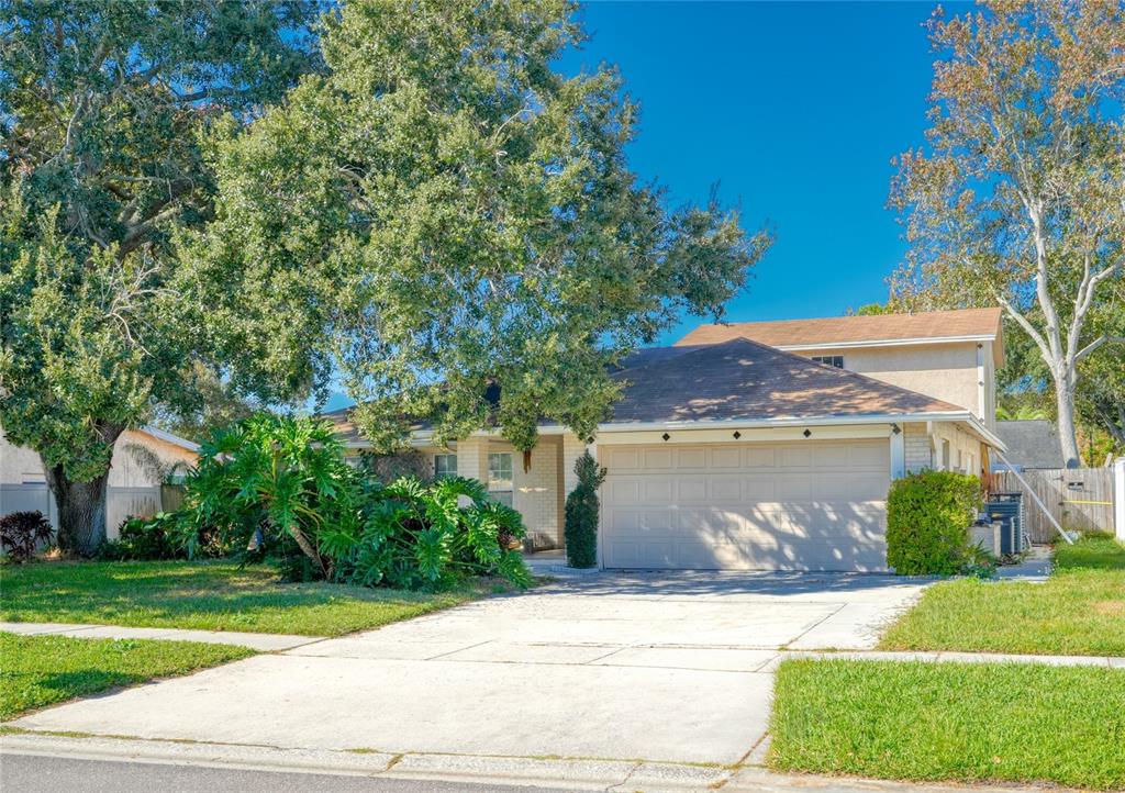 1432 Windmill Pointe Road Palm Harbor, FL 34685 - Photo 23 of 44 a front view of a house with a garden