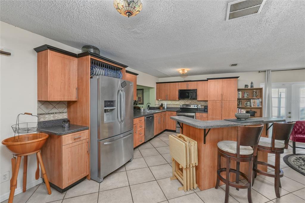 1432 Windmill Pointe Road Palm Harbor, FL 34685 - Photo 36 of 44 a kitchen with granite countertop a counter space cabinets and stainless steel appliances