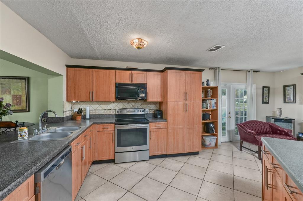 1432 Windmill Pointe Road Palm Harbor, FL 34685 - Photo 37 of 44 a kitchen with stainless steel appliances granite countertop a refrigerator and a stove top oven