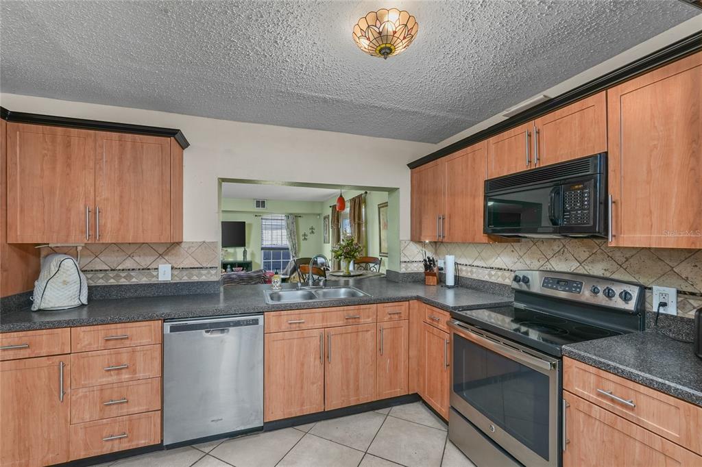 1432 Windmill Pointe Road Palm Harbor, FL 34685 - Photo 4 of 44 a kitchen with stainless steel appliances granite countertop a sink stove and microwave