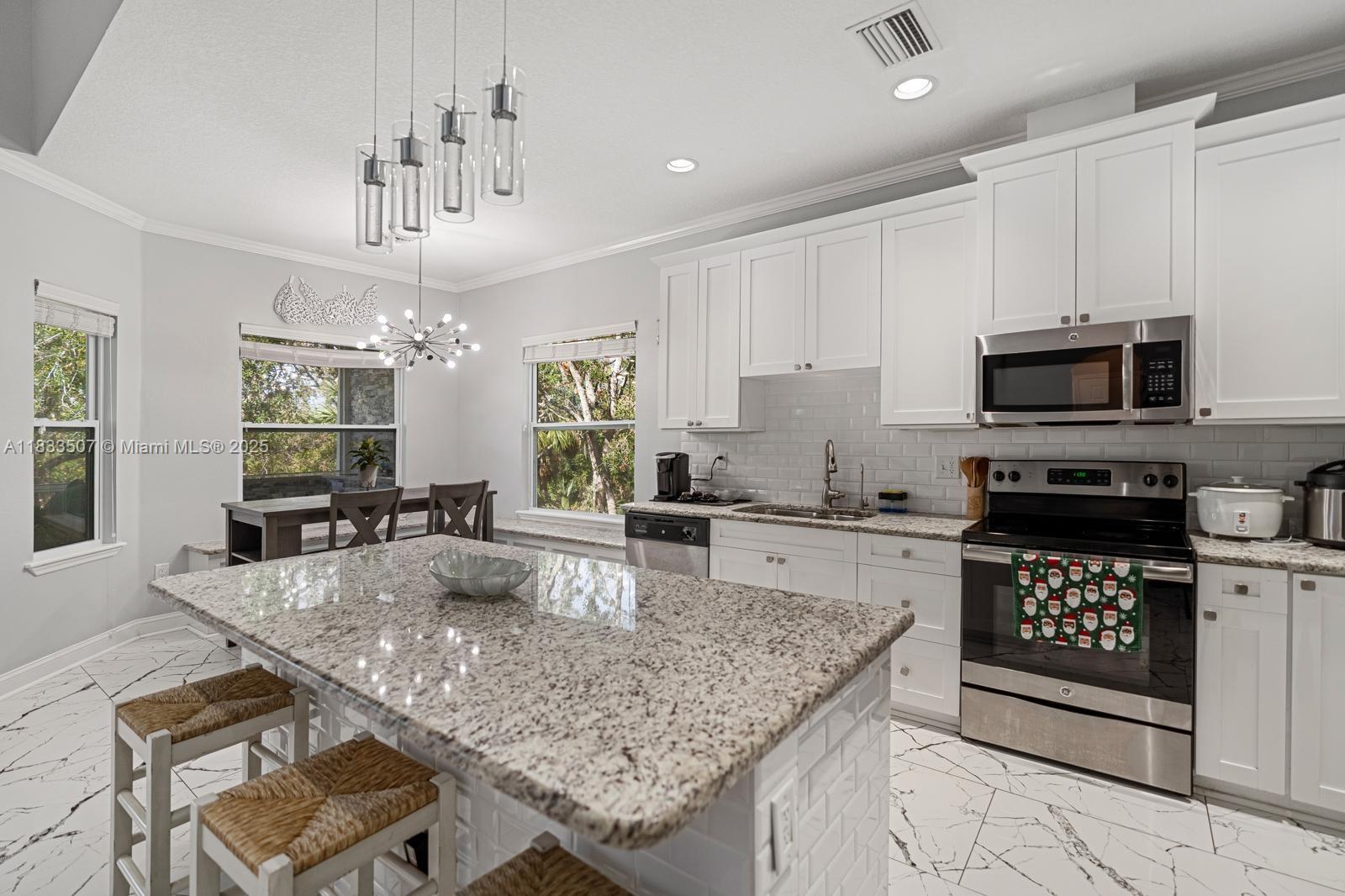 4836 Troydale Road Tampa, FL 33615 - Photo 17 of 52 a kitchen with stainless steel appliances granite countertop a sink stove and refrigerator