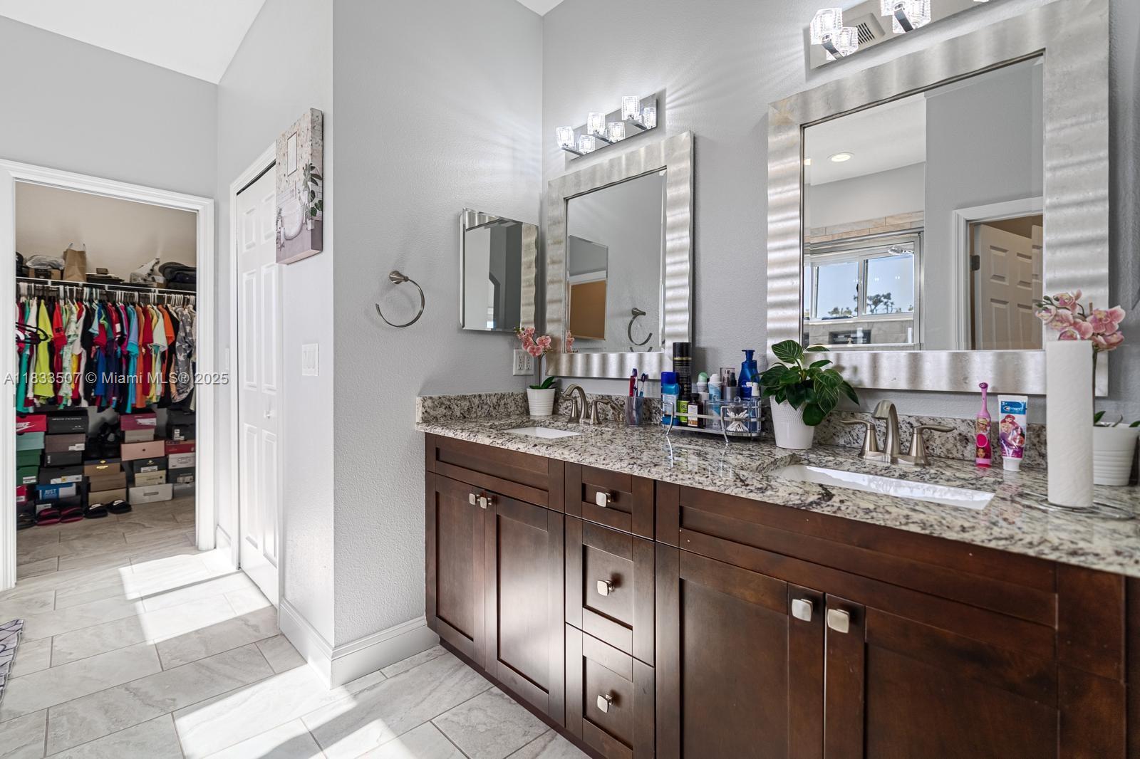 4836 Troydale Road Tampa, FL 33615 - Photo 29 of 52 a bathroom with a double vanity sink and a mirror