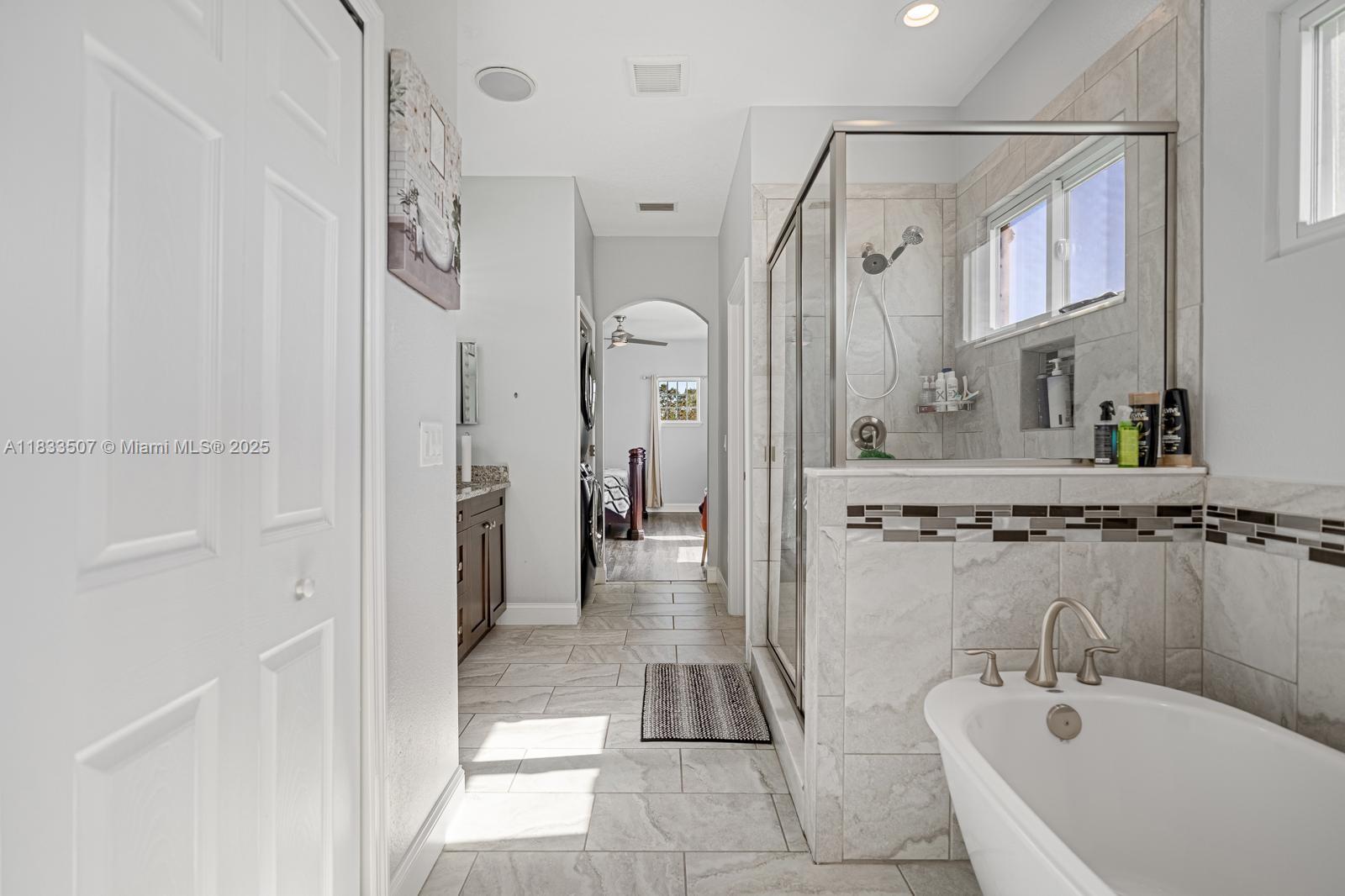 4836 Troydale Road Tampa, FL 33615 - Photo 30 of 52 a bathroom with a tub a sink and mirrors