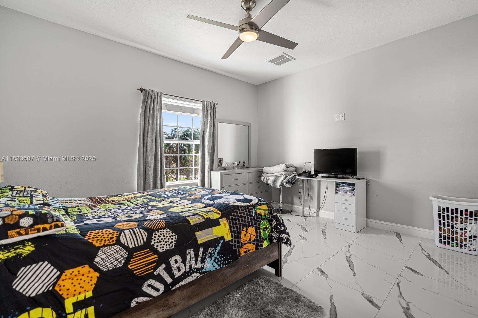 4836 Troydale Road Tampa, FL 33615 - Photo 33 of 52 a bedroom with a bed and a television