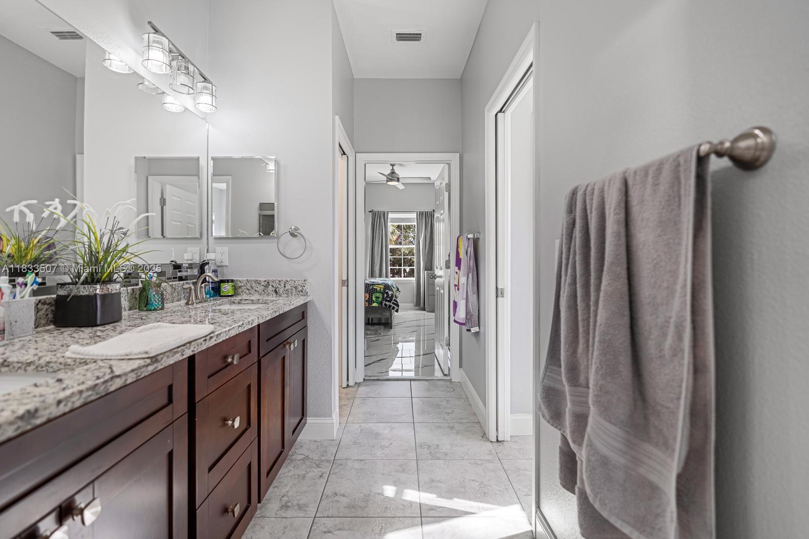 4836 Troydale Road Tampa, FL 33615 - Photo 34 of 52 a spacious bathroom with a granite countertop sink a mirror and a shower