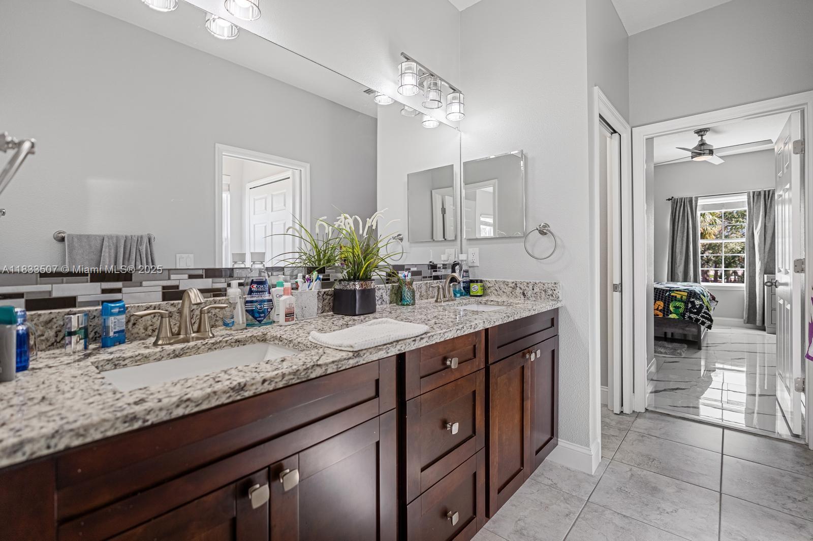 4836 Troydale Road Tampa, FL 33615 - Photo 35 of 52 a bathroom with a granite countertop sink and a mirror