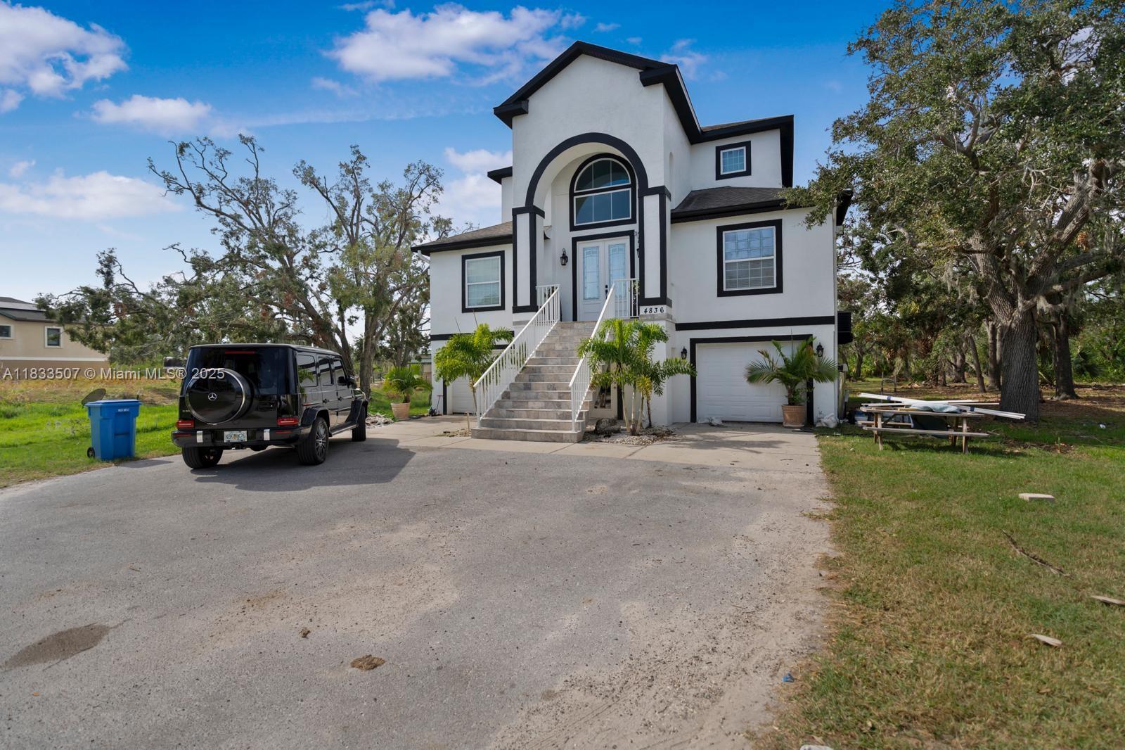 4836 Troydale Road Tampa, FL 33615 - Photo 5 of 52 a front view of a house with a garden and parking