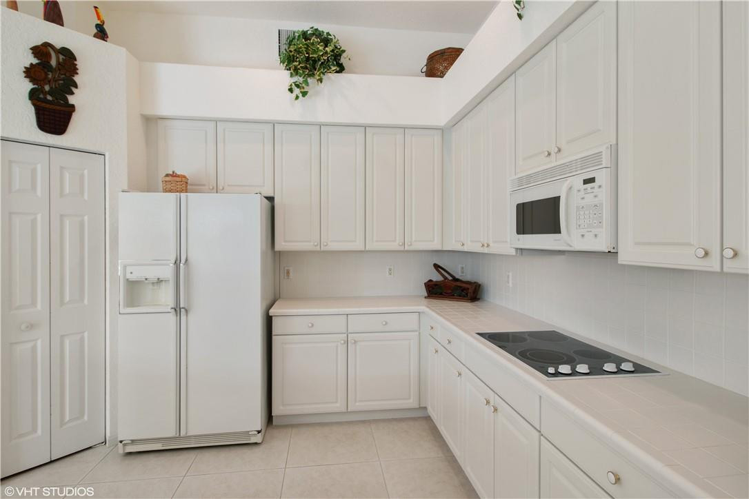 21389 Shannon Ridge Way Boca Raton, FL 33428 - Photo 6 of 21 a kitchen with white cabinets and white appliances