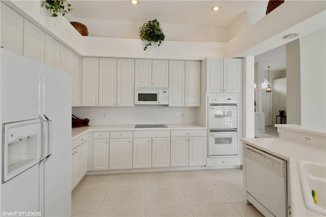 21389 Shannon Ridge Way Boca Raton, FL 33428 - Photo 8 of 21 a kitchen with white cabinets and white appliances