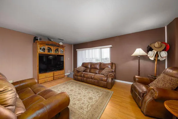 a living room with furniture a flat screen tv and a wall clock