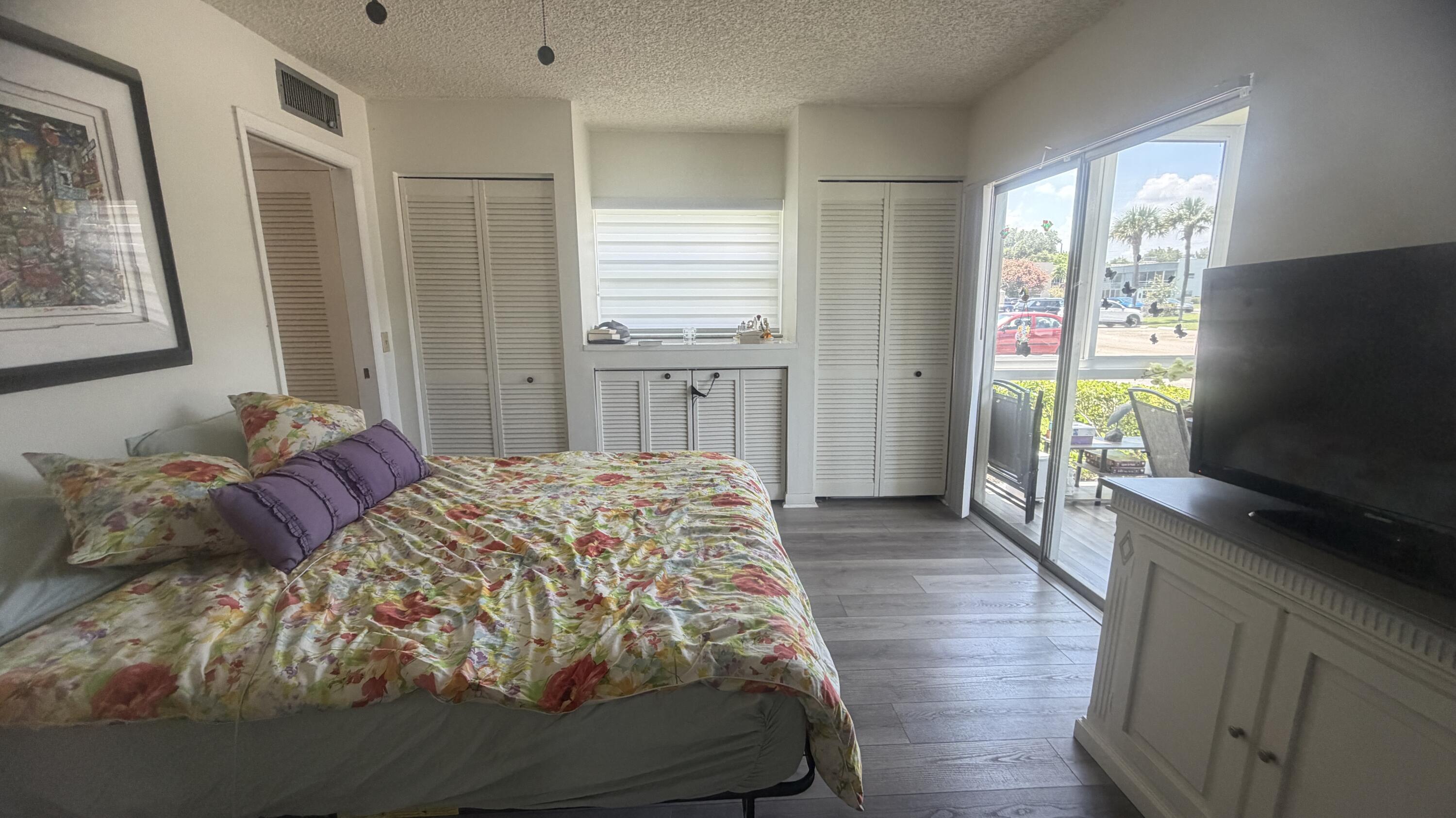 930 Normandy Trail Delray Beach, FL 33484 - Photo 9 of 34 a bedroom with a bed and a flat screen tv