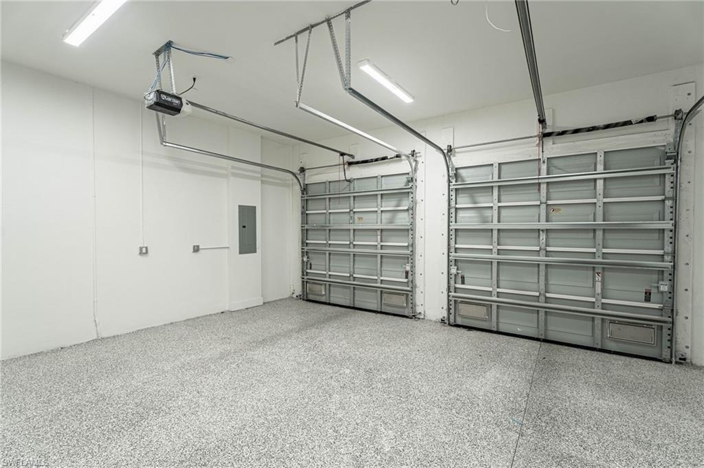 5816 Shell Cove Drive Cape Coral, FL 33914 - Photo 10 of 16 Garage featuring electric panel and a garage door opener