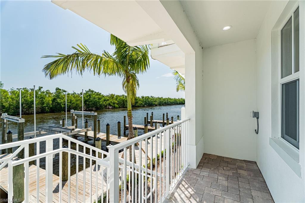 5816 Shell Cove Drive Cape Coral, FL 33914 - Photo 15 of 16 Balcony with a water view, a boat dock, boat lift, and view of scattered trees