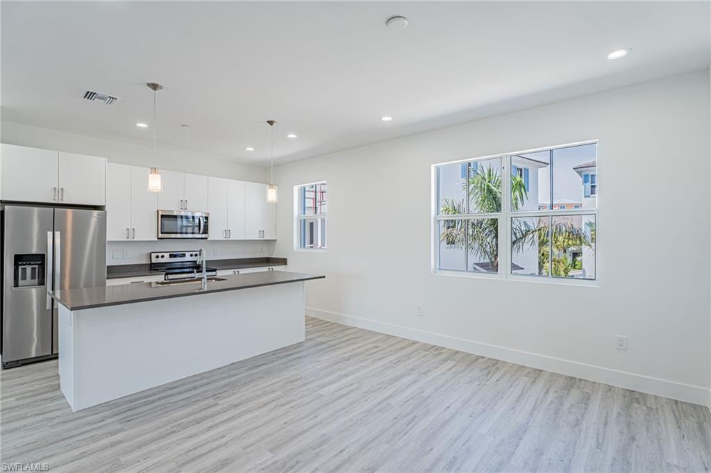 5816 Shell Cove Drive Cape Coral, FL 33914 - Photo 4 of 16 Kitchen with stainless steel appliances, decorative light fixtures, an island with sink, recessed lighting, and white cabinets