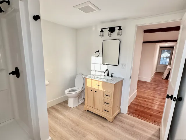 a bathroom with a toilet sink and mirror