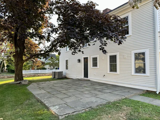 a view of a house with a yard and tree