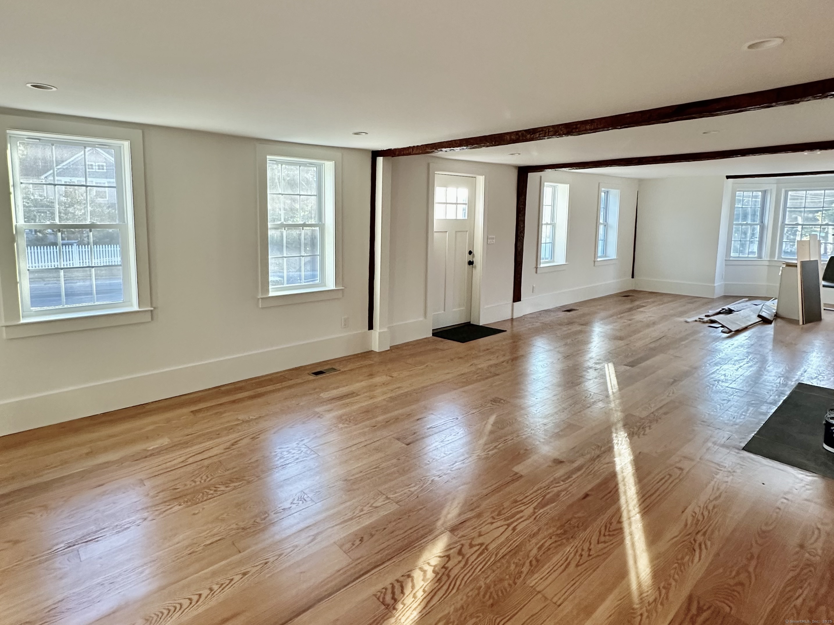 2318 Mill Plain Road Fairfield, CT 06824 - Photo 2 of 14 a view of an empty room with wooden floor and a window