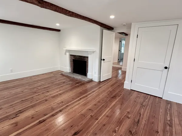 a view of empty room with wooden floor