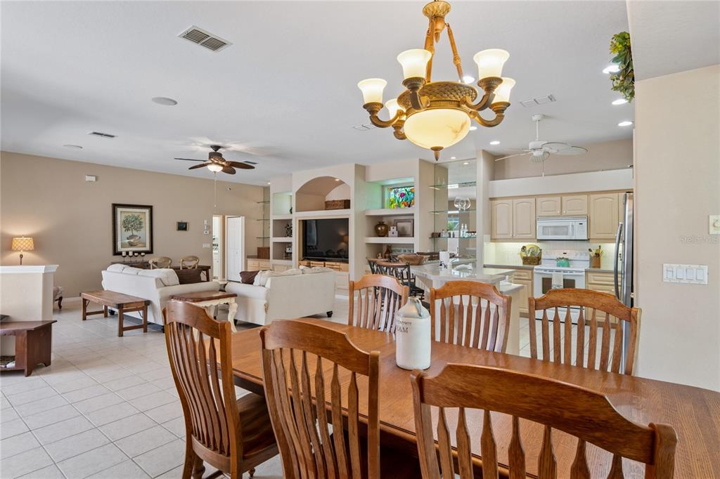 10120 Shortleaf Court Weeki Wachee, FL 34613 - Photo 30 of 95 a view of a dining room and livingroom with furniture a chandelier a rug a fireplace and a chandelier