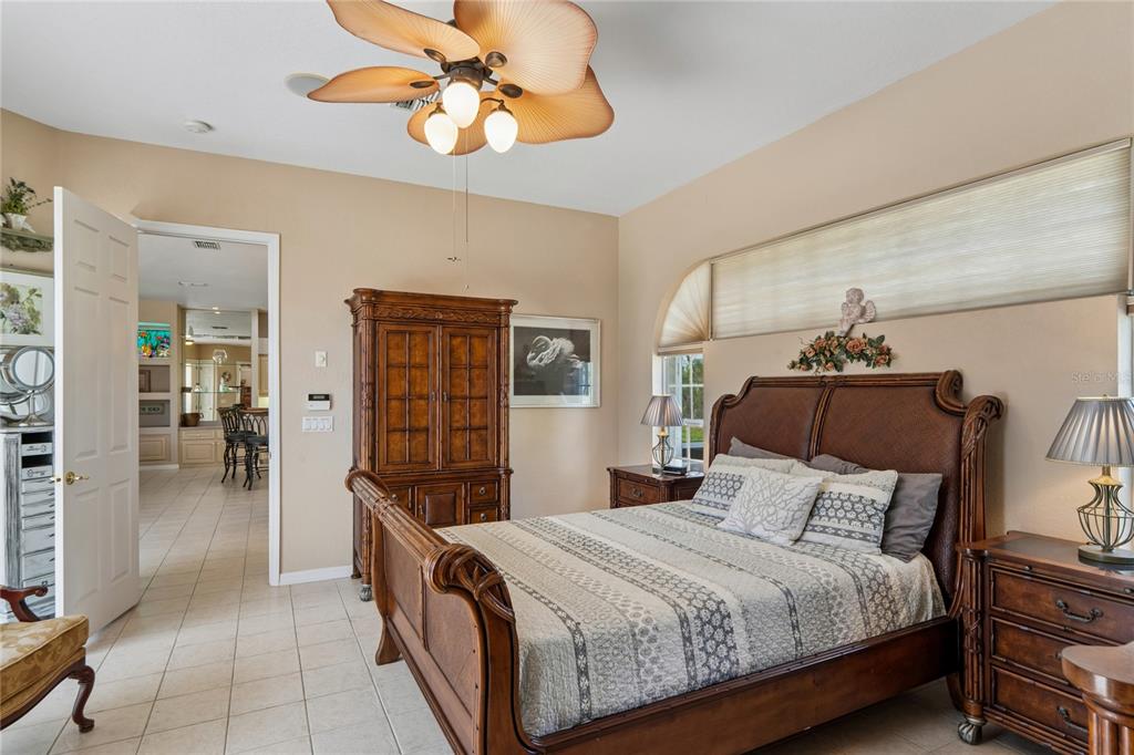 10120 Shortleaf Court Weeki Wachee, FL 34613 - Photo 33 of 95 a bedroom with a bed and a chandelier