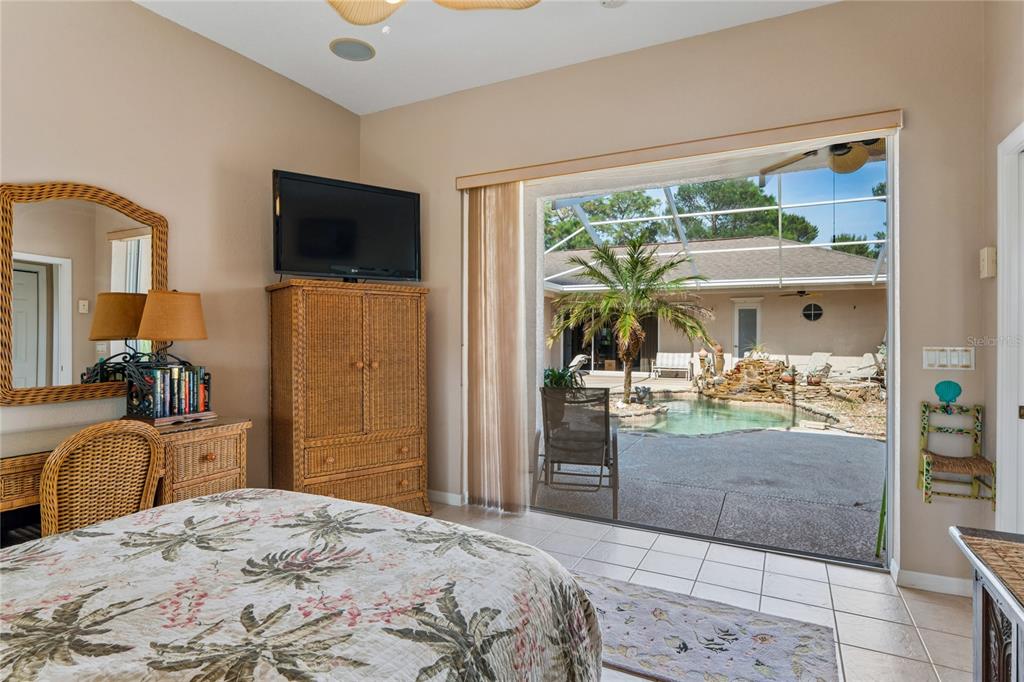 10120 Shortleaf Court Weeki Wachee, FL 34613 - Photo 59 of 95 a bedroom with a balcony a bed and a television