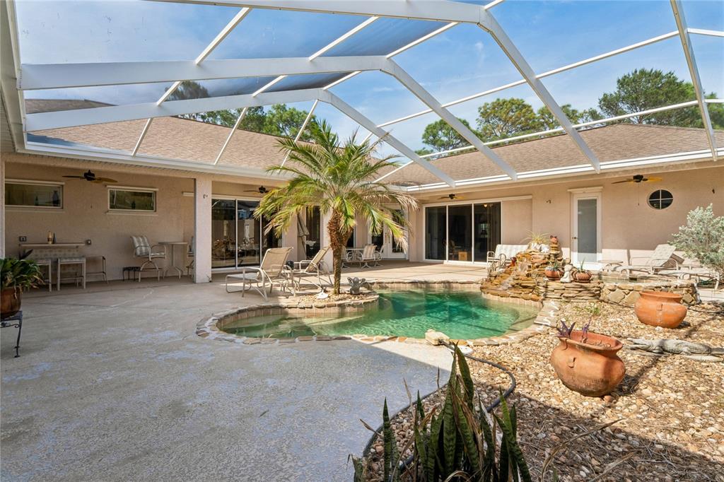 10120 Shortleaf Court Weeki Wachee, FL 34613 - Photo 70 of 95 a view of a backyard with table and chairs under an umbrella