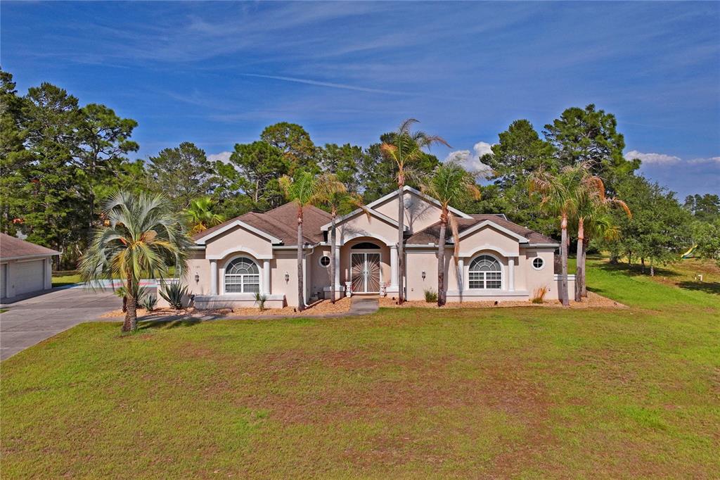 10120 Shortleaf Court Weeki Wachee, FL 34613 - Photo 94 of 95 a front view of a house with a yard and trees