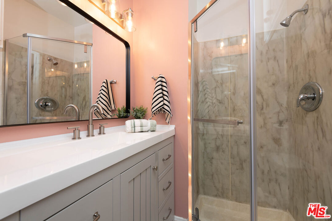 5403 Newcastle Avenue, Unit 69 Encino, CA 91316 - Photo 15 of 34 a bathroom with a shower sink and mirror