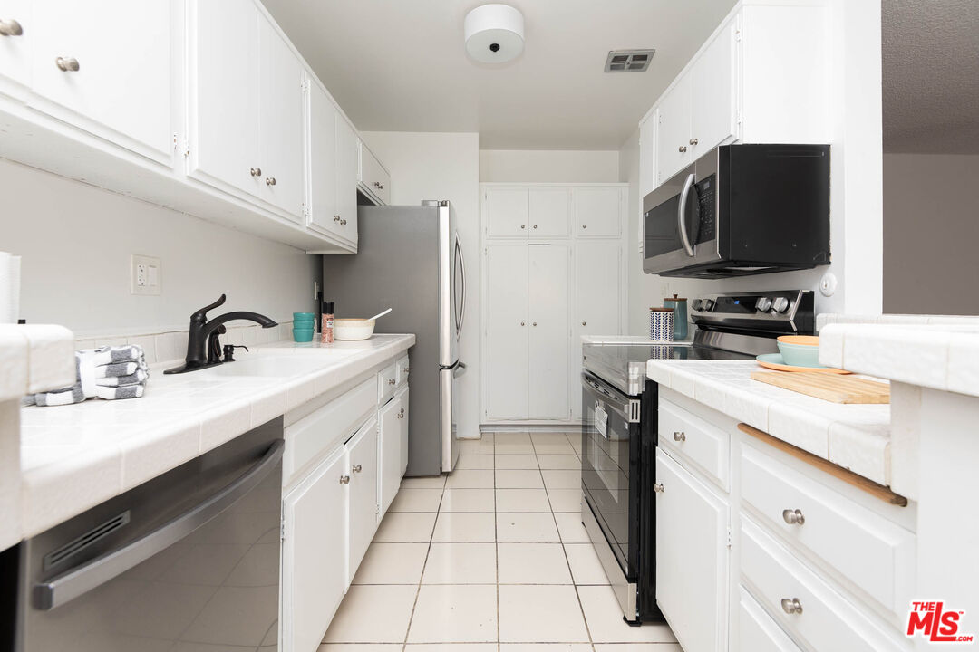 5403 Newcastle Avenue, Unit 69 Encino, CA 91316 - Photo 6 of 34 a kitchen with a sink stove and refrigerator