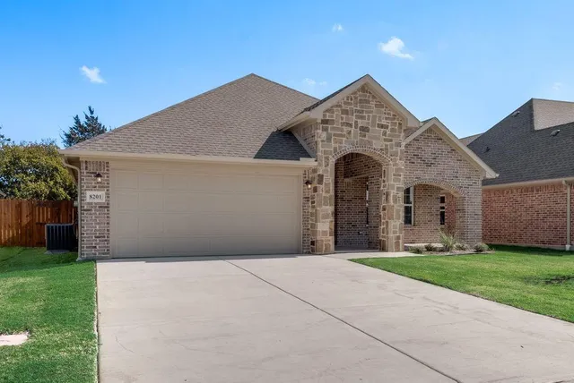 a front view of a house with yard and garage