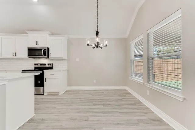 a kitchen with granite countertop a stove a sink and a refrigerator