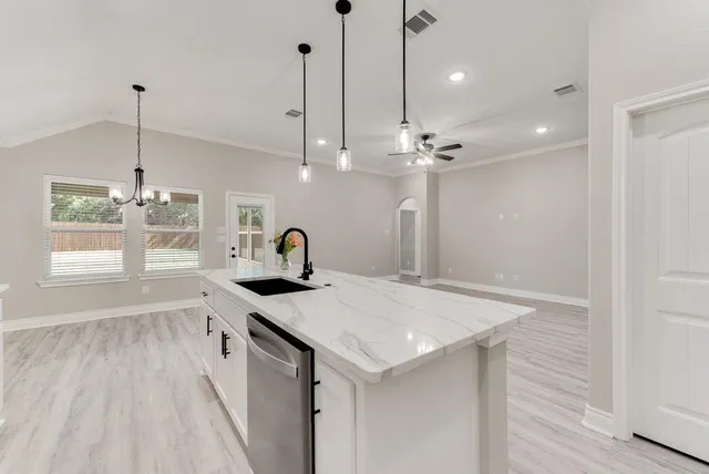 a kitchen with a sink a counter space and wooden floor