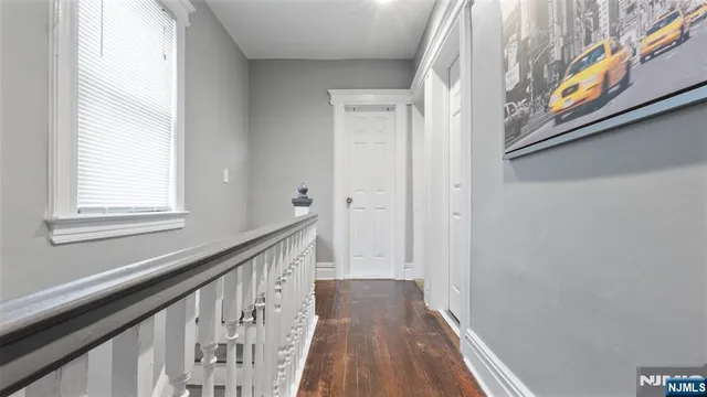 a view of a hallway with wooden floor and staircase