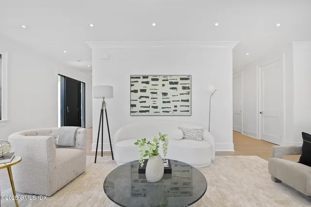 a living room with furniture flowerpot and wooden floor