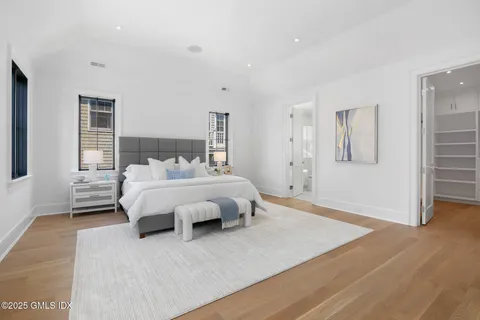 a bedroom with a bed and a large window