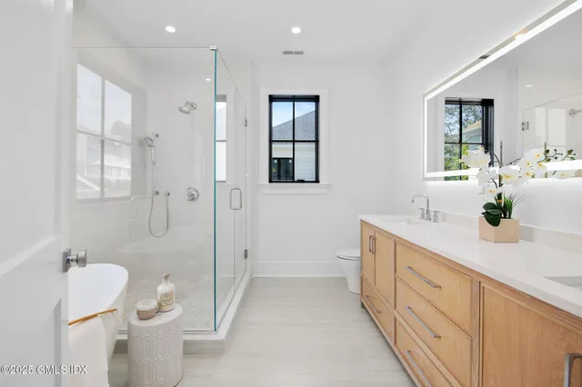 a spacious bathroom with a double vanity sink toilet and shower