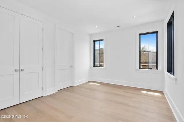 a view of an empty room with closet and a window