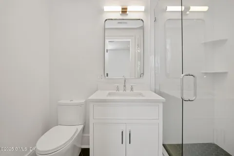 a bathroom with a toilet sink shower and mirror