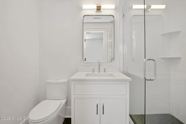 a bathroom with a toilet sink shower and mirror