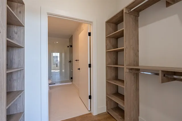 a view of walk in closet with empty racks