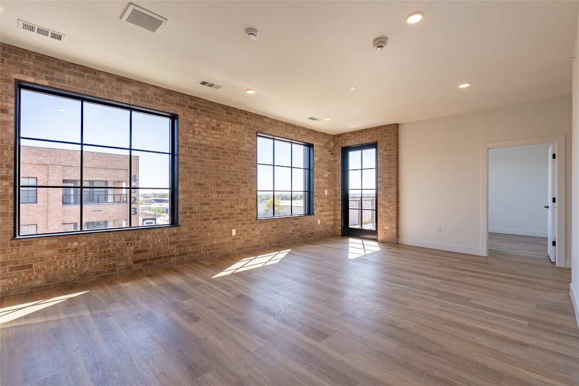4315 South Congress Avenue, Unit 504 Austin, TX 78745 - Photo 2 of 21 Spare room with recessed lighting, wood finished floors, and brick wall