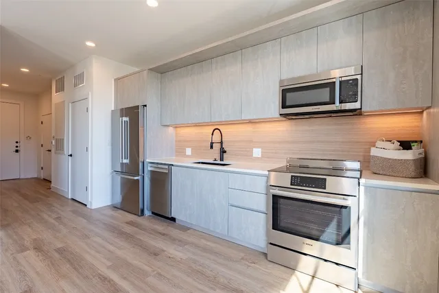 a kitchen with stainless steel appliances granite countertop a refrigerator and a stove top oven