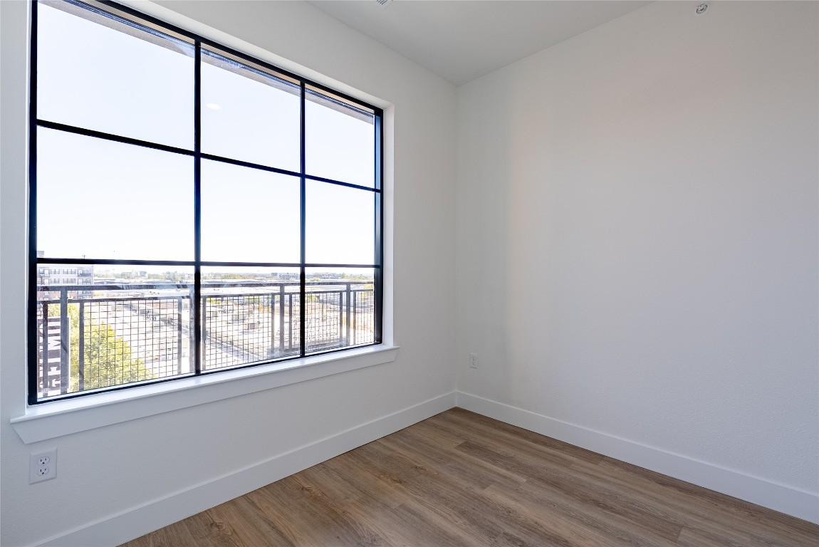 4315 South Congress Avenue, Unit 504 Austin, TX 78745 - Photo 7 of 21 Unfurnished room featuring baseboards and wood finished floors