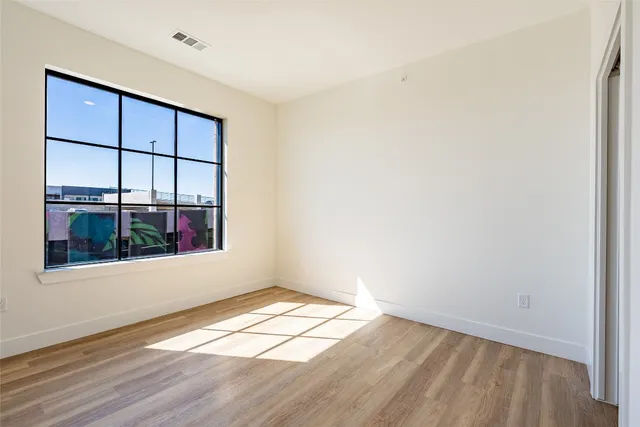 an empty room with wooden floor and a window